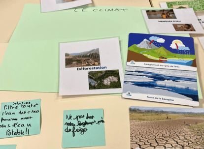 Photos et post-it sur la déforestation et le dérèglement climatique posés sur une table